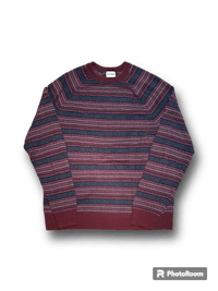 a burgundy and blue striped sweater on a black background